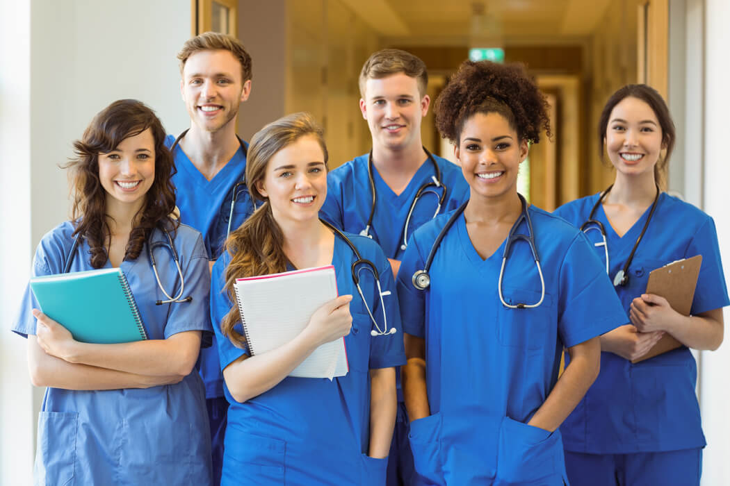 A group of prospective doctors wear women's scrubs and men's scrubs